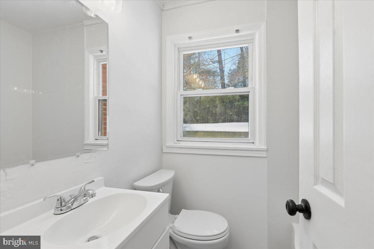 9704 Lorain Avenue Silver Spring, MD 20901 - Photo 12 of 26 a white toilet sitting next to a bathroom sink