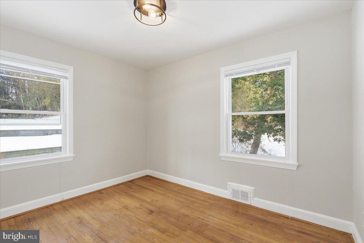 9704 Lorain Avenue Silver Spring, MD 20901 - Photo 14 of 26 a view of an empty room with wooden floor and a window