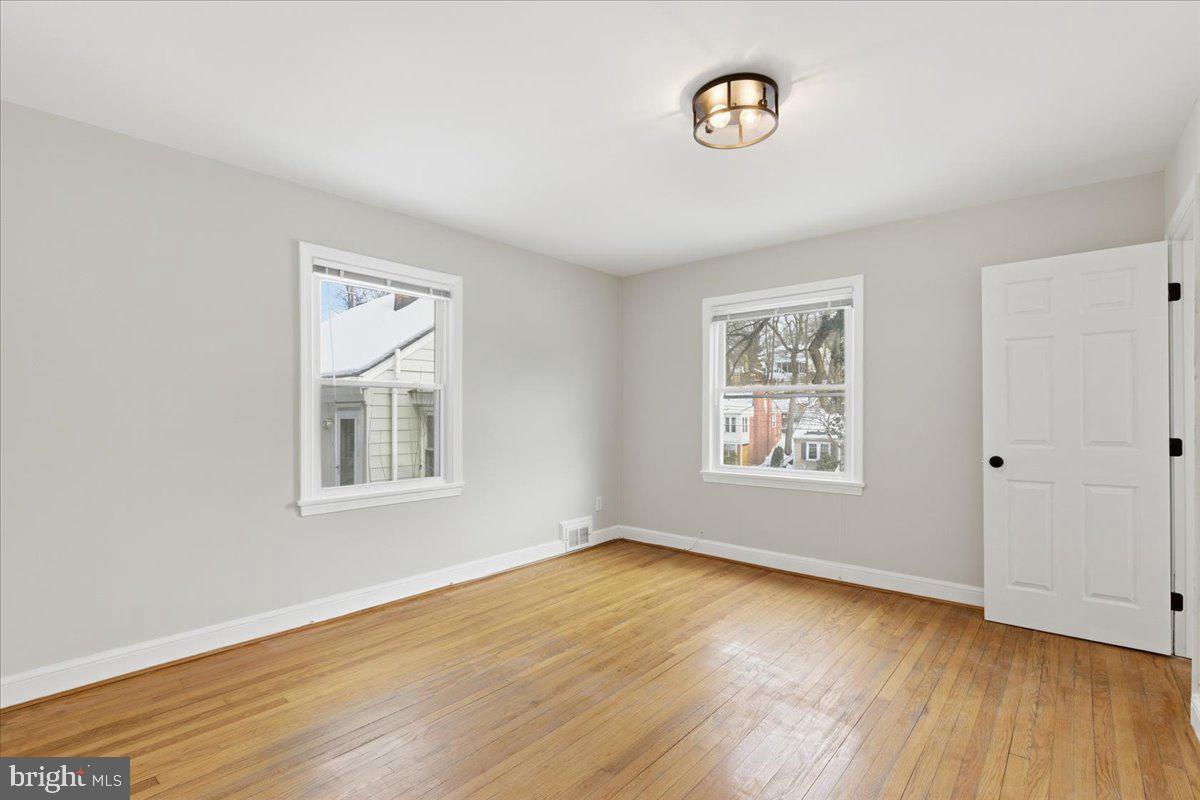 9704 Lorain Avenue Silver Spring, MD 20901 - Photo 16 of 26 a view of an empty room with wooden floor and a window