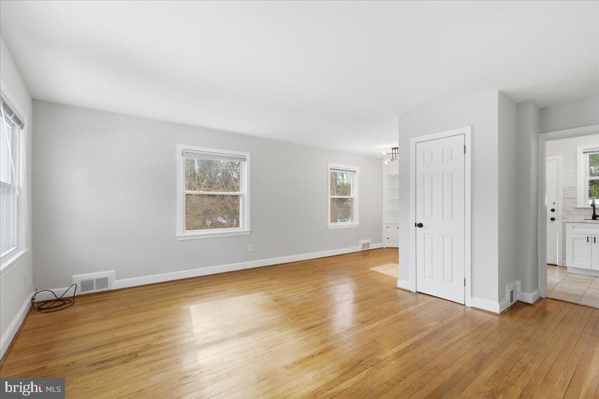 9704 Lorain Avenue Silver Spring, MD 20901 - Photo 2 of 26 an empty room with wooden floor and windows