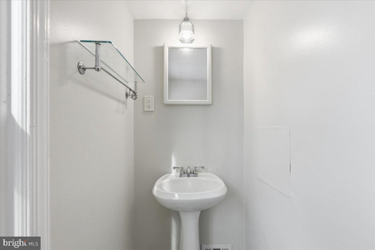 9704 Lorain Avenue Silver Spring, MD 20901 - Photo 21 of 26 a bathroom with a sink a mirror and a shower