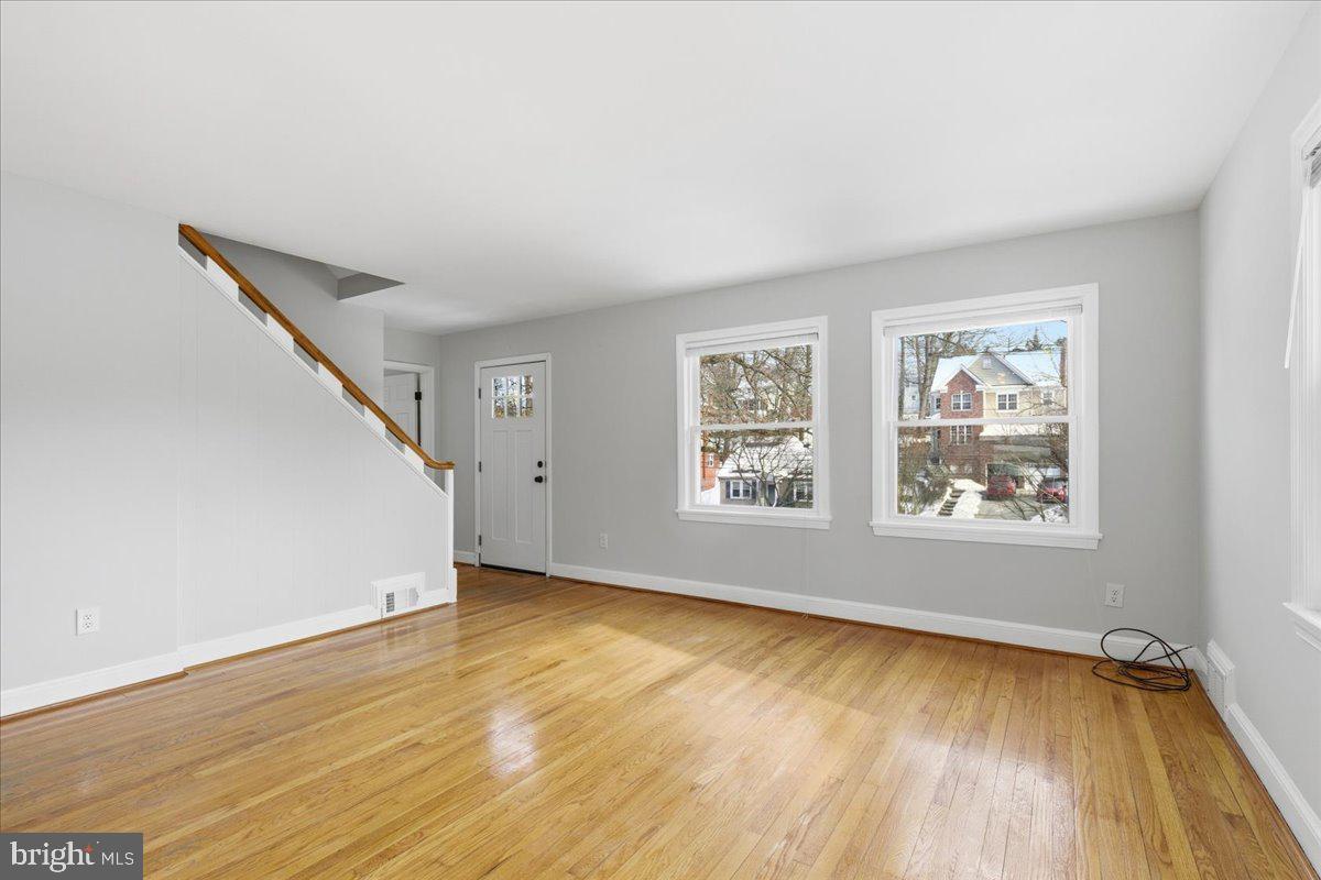 9704 Lorain Avenue Silver Spring, MD 20901 - Photo 4 of 26 a view of an empty room with wooden floor and a window