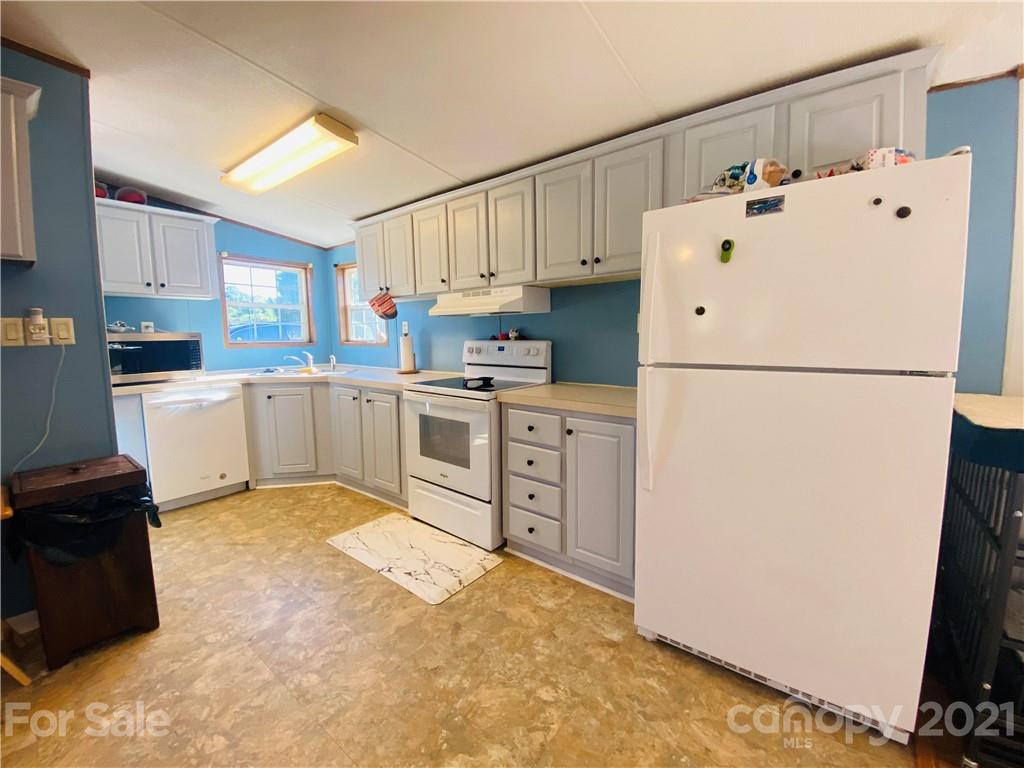 46 Austin Road Clyde, NC 28721 - Photo 9 of 20 a kitchen with white cabinets and white appliances
