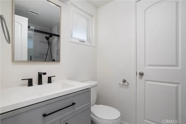 a bathroom with a sink a toilet a shower and mirror
