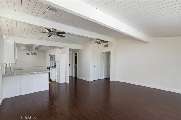 a view of empty room with wooden floor and window