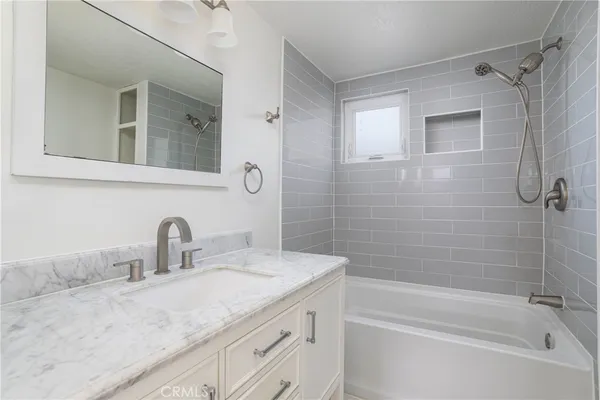 a bathroom with a granite countertop sink mirror toilet and bathtub