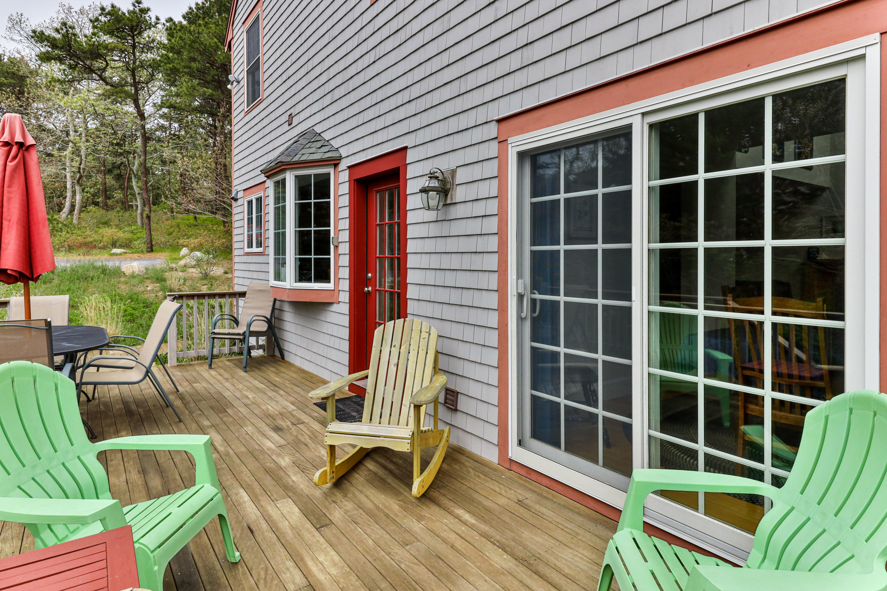 39 South Highland Road Truro, MA 02666 - Photo 45 of 46 a view of a deck with table and chairs and floor to ceiling window and wooden floor
