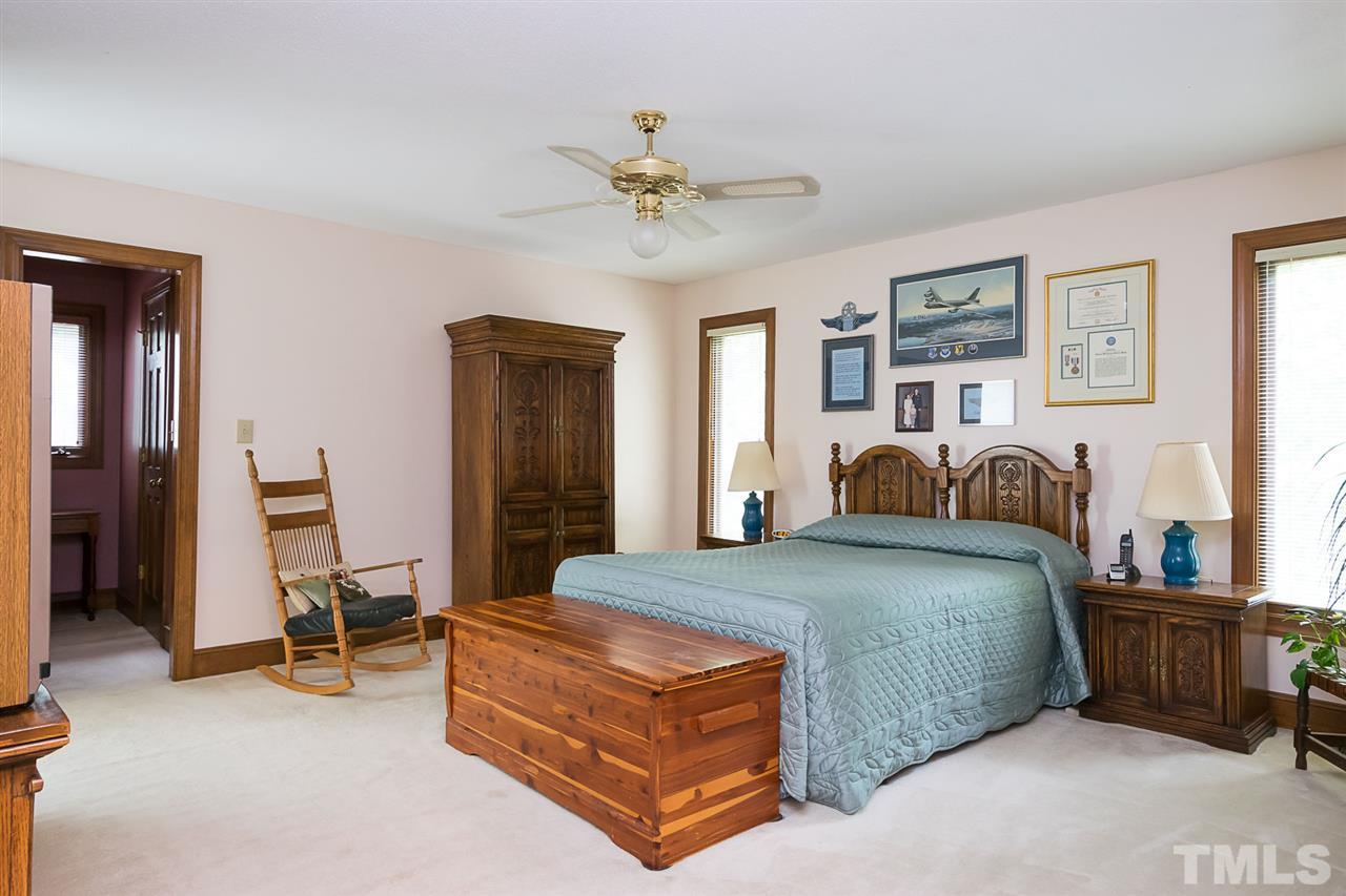 3020 Daventry Lane Raleigh, NC 27613 - Photo 13 of 25 a bedroom with a bed and a chandelier