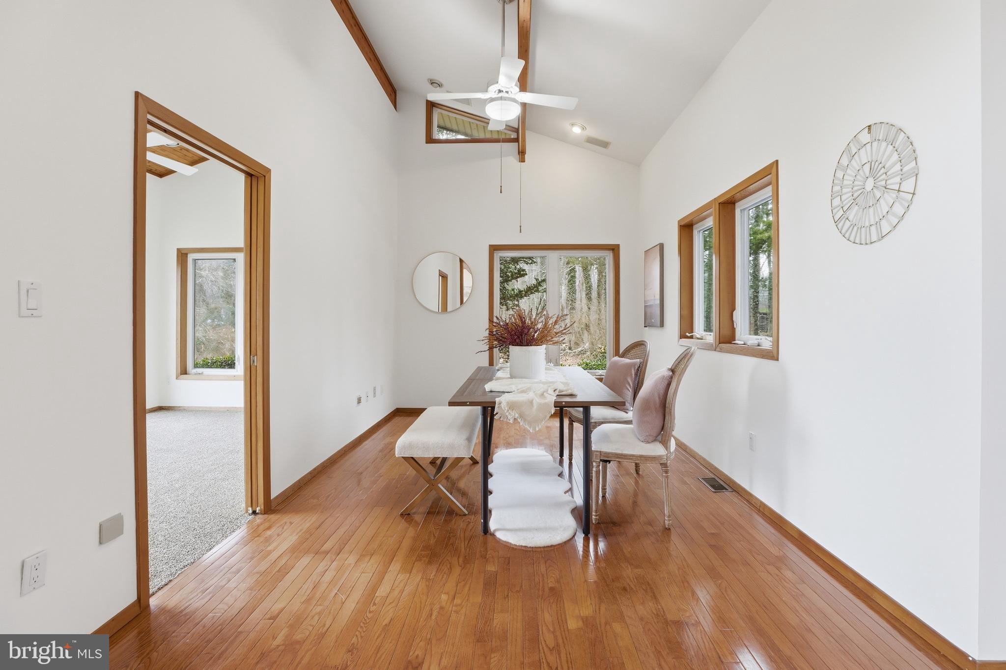 5931 Tyler Road Deale, MD 20751 - Photo 23 of 77 a dining room with wooden floor a glass table and chairs