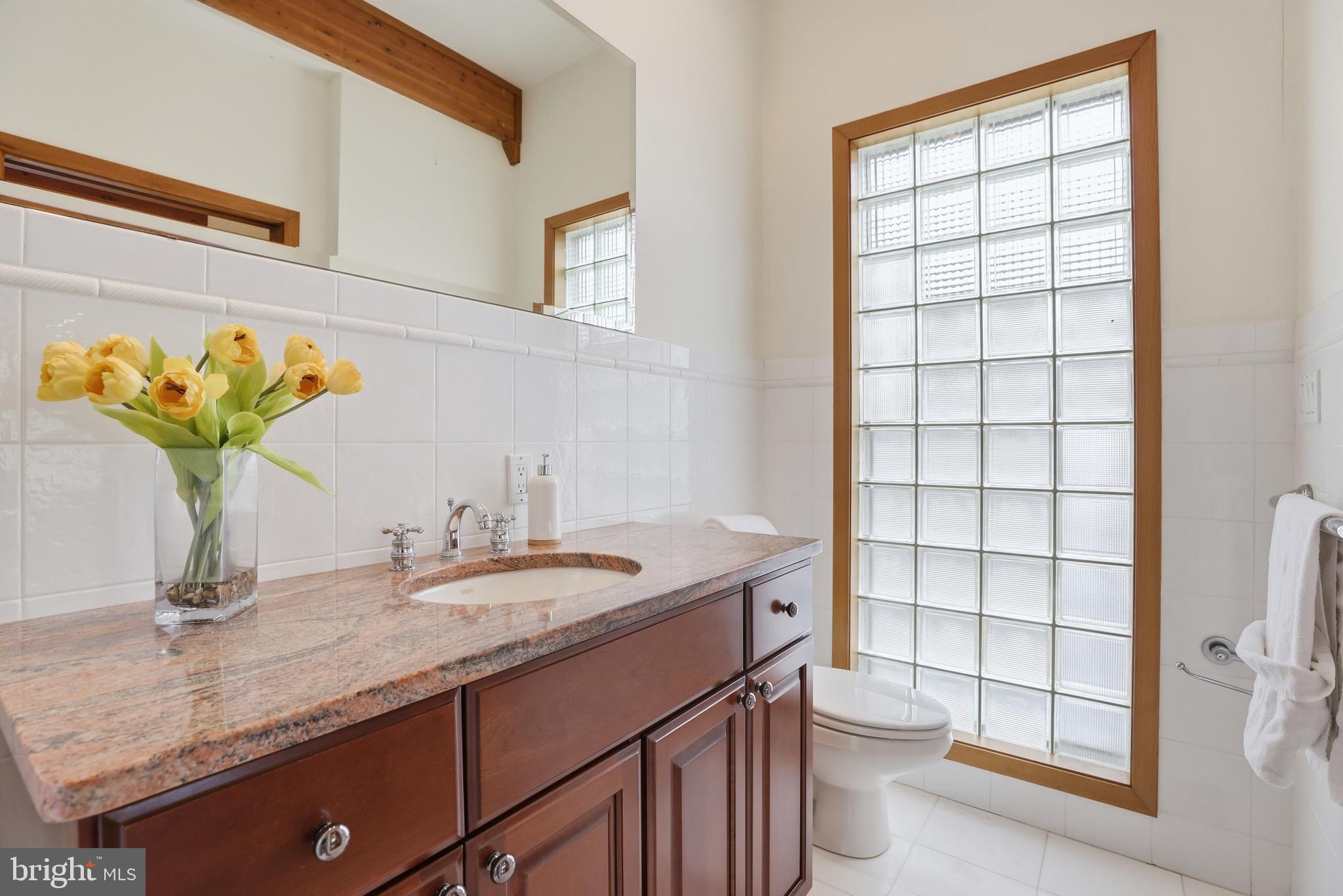 5931 Tyler Road Deale, MD 20751 - Photo 38 of 77 a bathroom with a granite countertop sink a toilet and a mirror
