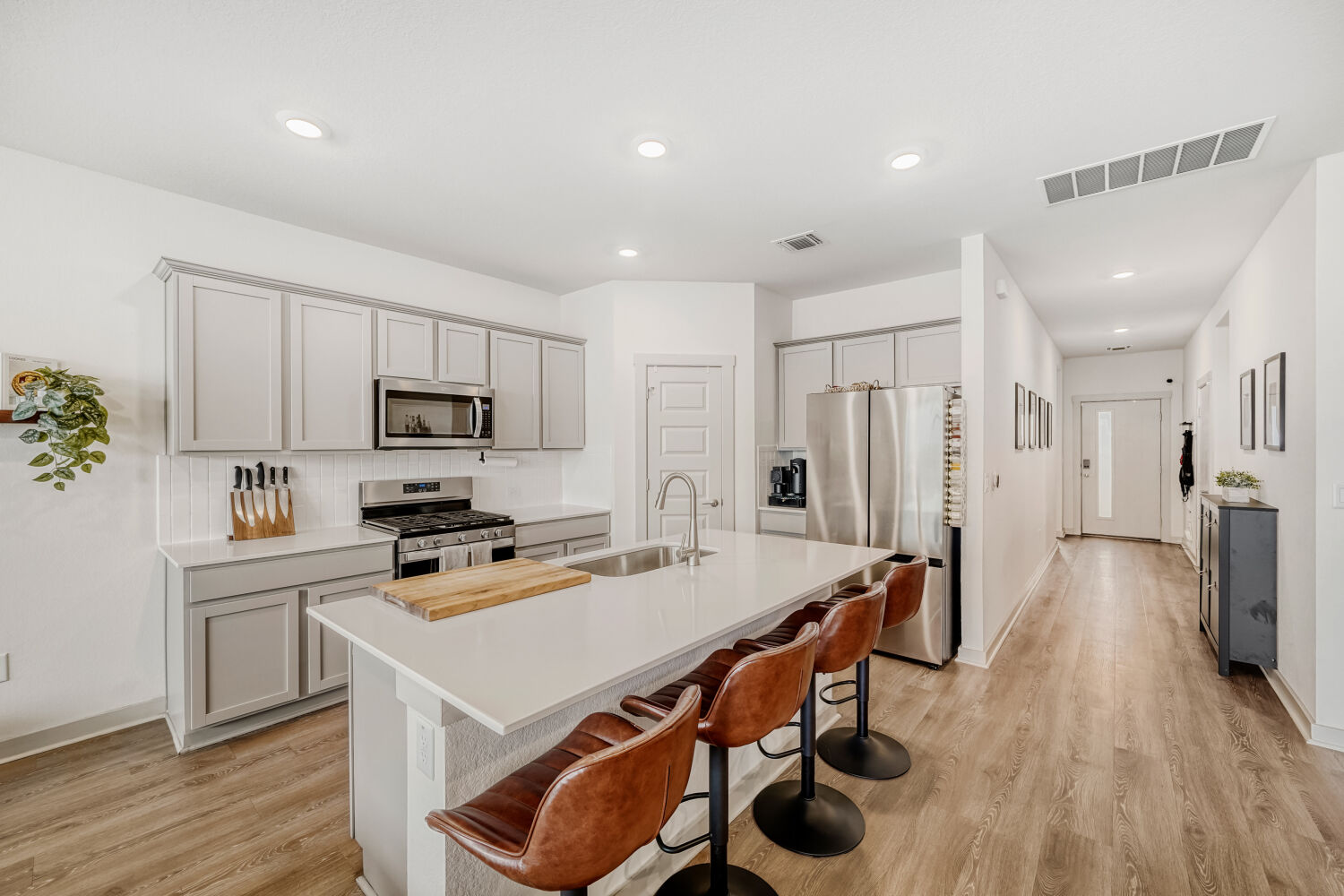 2308 Ranier Court Austin, TX 78754 - Photo 14 of 29 Kitchen featuring stainless steel appliances, a breakfast bar, a center island with sink, light wood finished floors, and recessed lighting