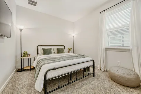 a bedroom with a bed and a potted plant