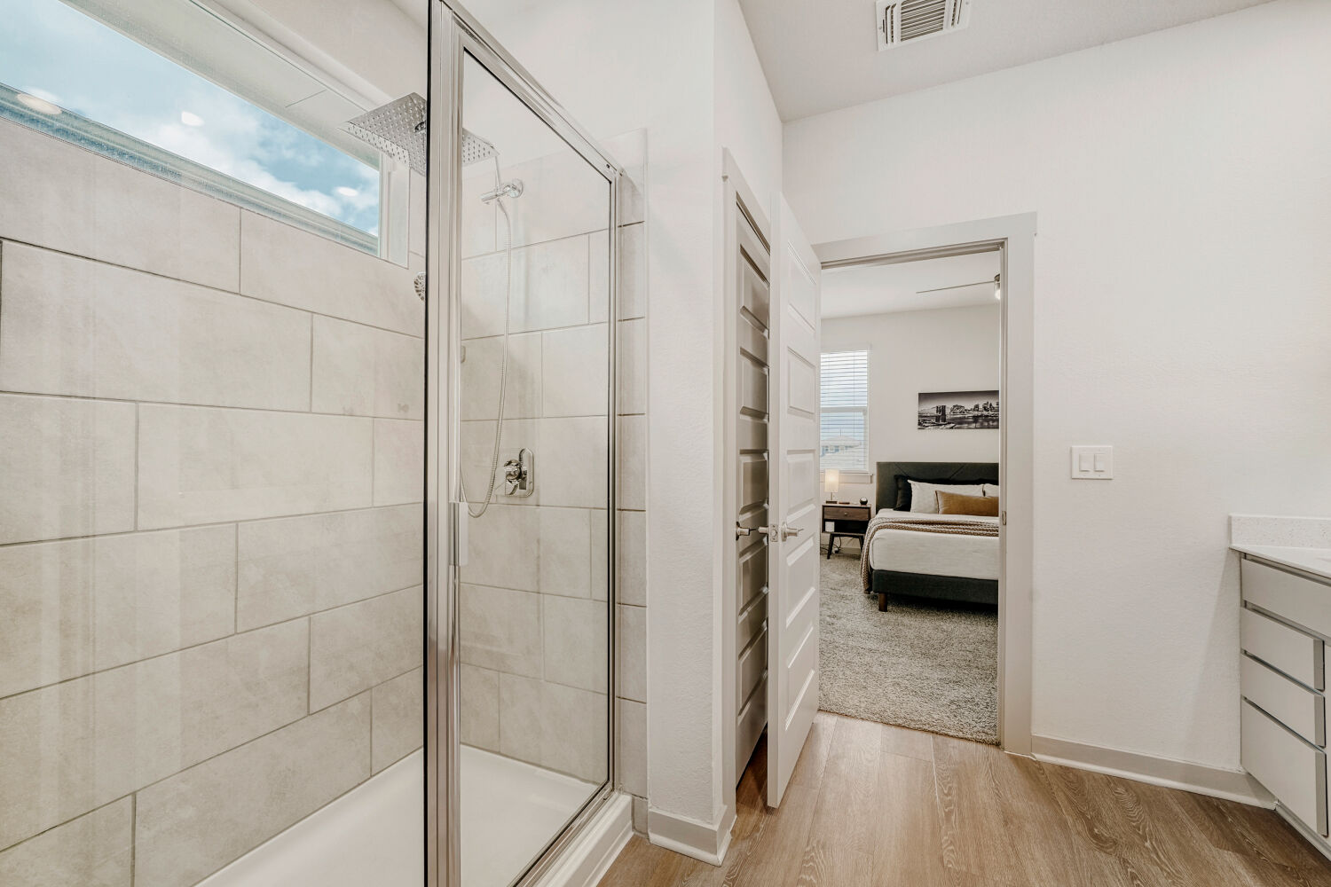 2308 Ranier Court Austin, TX 78754 - Photo 20 of 29 Ensuite bathroom featuring healthy amount of natural light, vanity, a shower stall, and light wood-style flooring