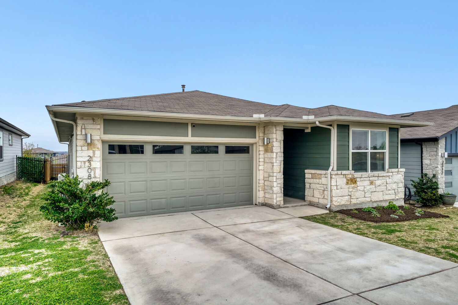 2308 Ranier Court Austin, TX 78754 - Photo 3 of 29 View of front facade with stone siding, concrete driveway, and a garage