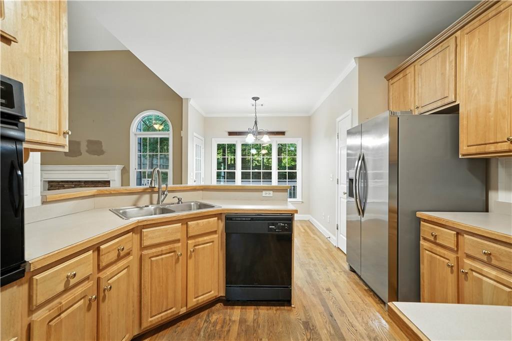 6745 Fairfield Trace Suwanee, GA 30024 - Photo 14 of 37 a kitchen with granite countertop a refrigerator a sink dishwasher and white cabinets with wooden floor