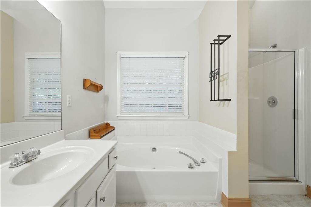 6745 Fairfield Trace Suwanee, GA 30024 - Photo 20 of 37 a bathroom with a tub a sink and a window