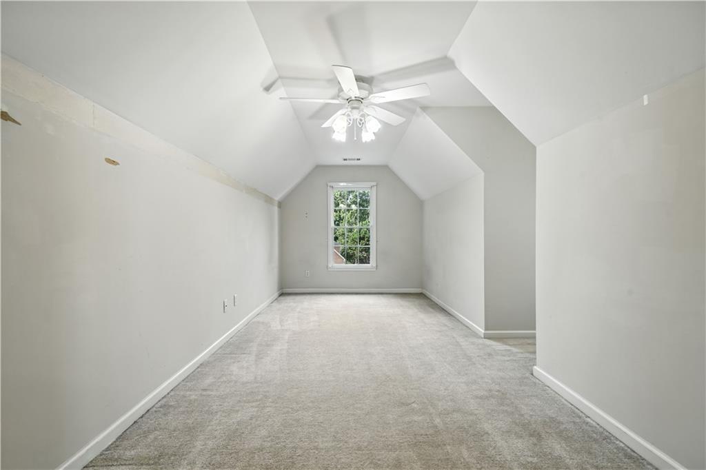 6745 Fairfield Trace Suwanee, GA 30024 - Photo 27 of 37 an empty room with windows and chandelier fan