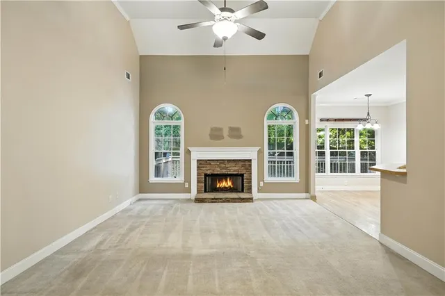 a view of an empty room with a fireplace and a window
