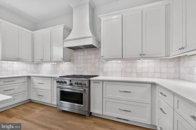 a kitchen with white cabinets and a stove