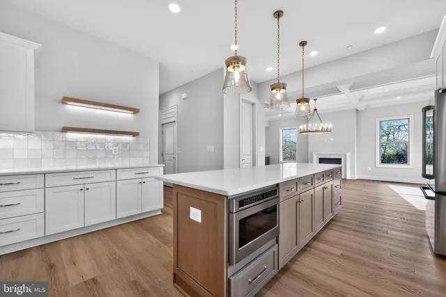 a kitchen with stainless steel appliances granite countertop a stove and a wooden floors