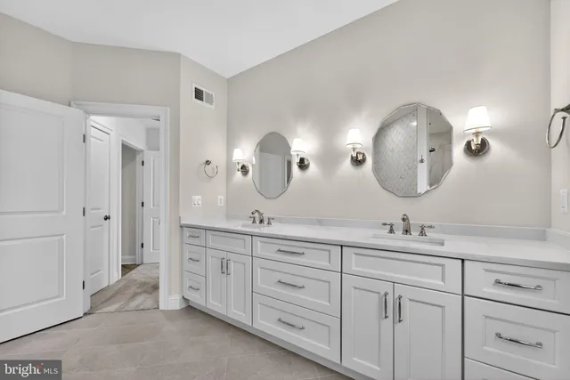 a spacious bathroom with 2 sink and a mirror