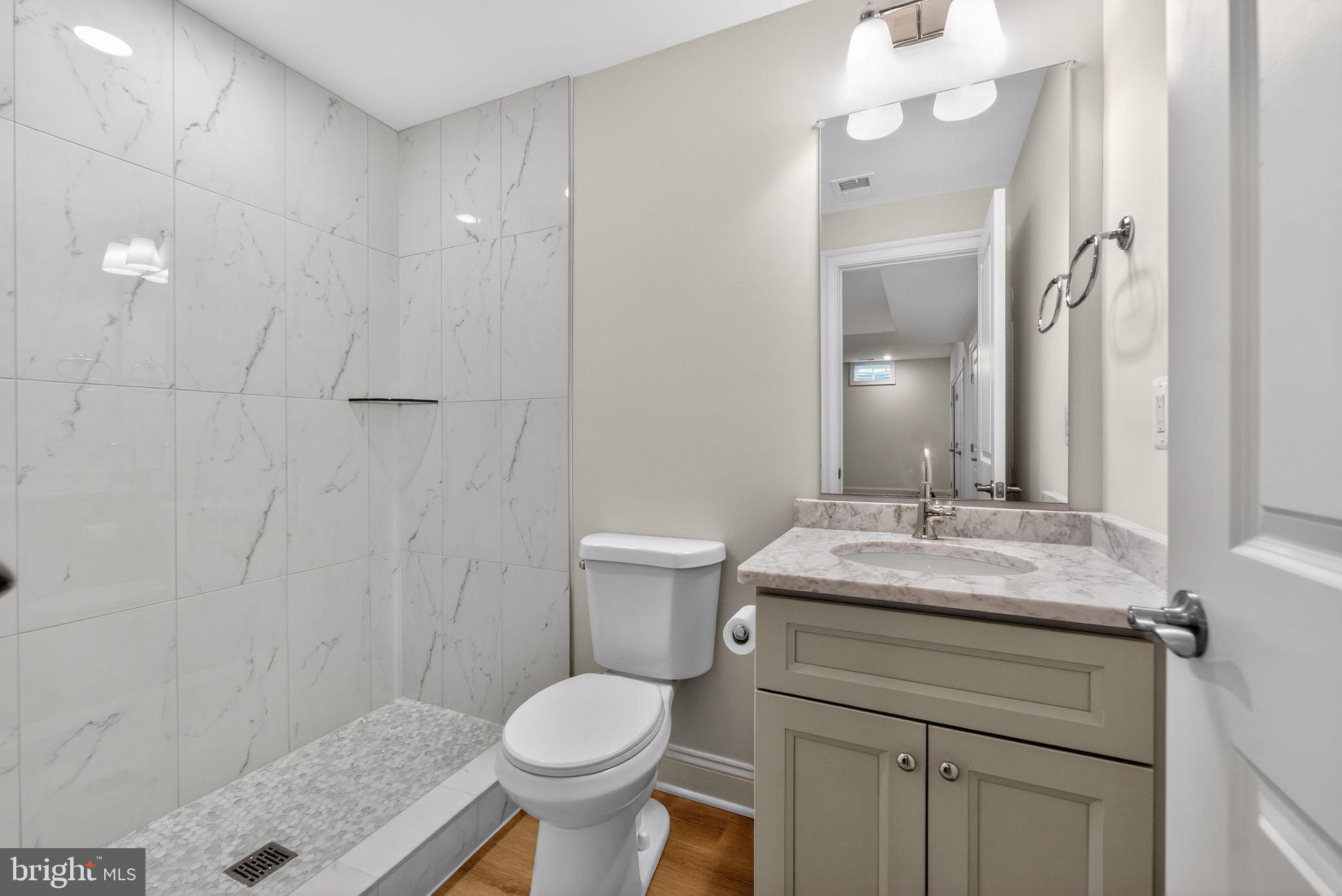 626 A Old County Road Severna Park, MD 21146 - Photo 47 of 52 a bathroom with a granite countertop sink a toilet and a mirror