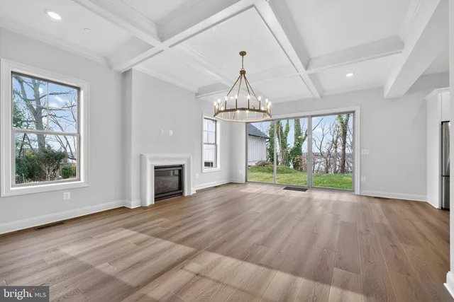 a view of empty room with wooden floor and fireplace