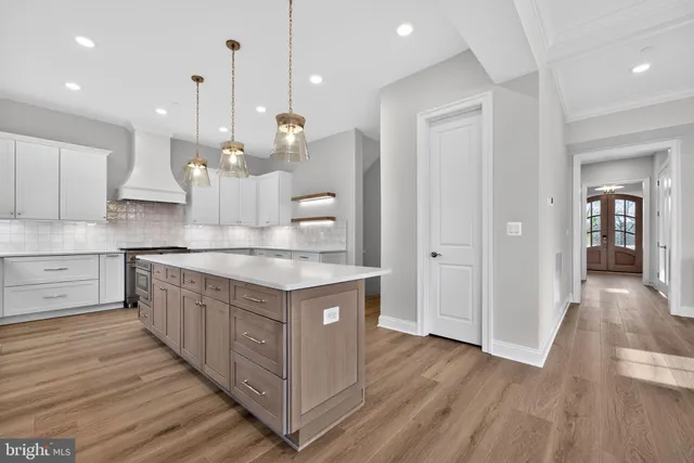 a kitchen with kitchen island a counter top space a sink stainless steel appliances and cabinets