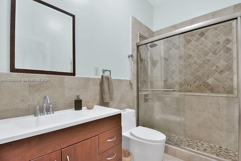 5425 Southwest 190th Avenue Southwest Ranches, FL 33332 - Photo 12 of 56 a bathroom with a sink a mirror a toilet and a shower