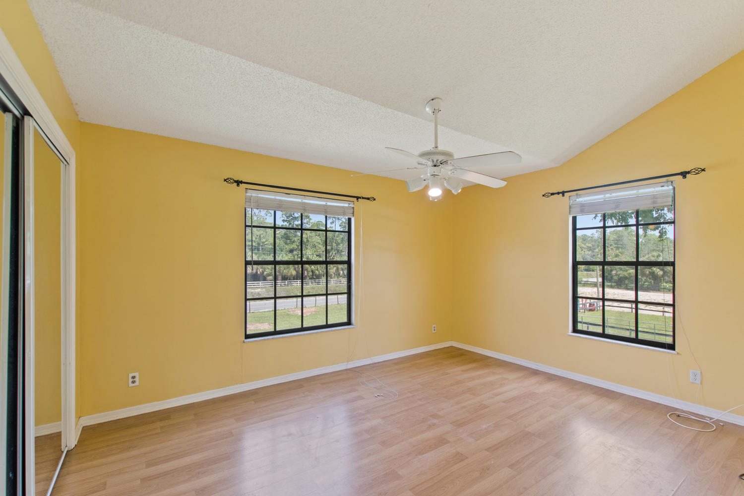 1350 C Road Loxahatchee Groves, FL 33470 - Photo 10 of 27 an empty room with windows and chandelier fan