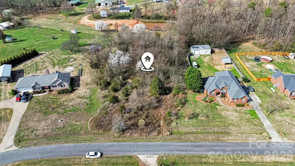 an aerial view of a house with a yard and large trees