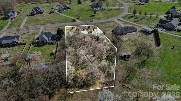 a view of a yard with wooden fence