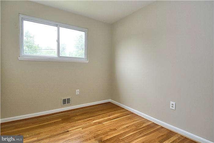 305 Irwin Street Silver Spring, MD 20901 - Photo 15 of 23 an empty room with wooden floor and windows