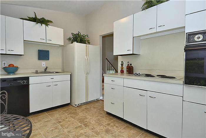 305 Irwin Street Silver Spring, MD 20901 - Photo 7 of 23 a kitchen with white cabinets and white appliances