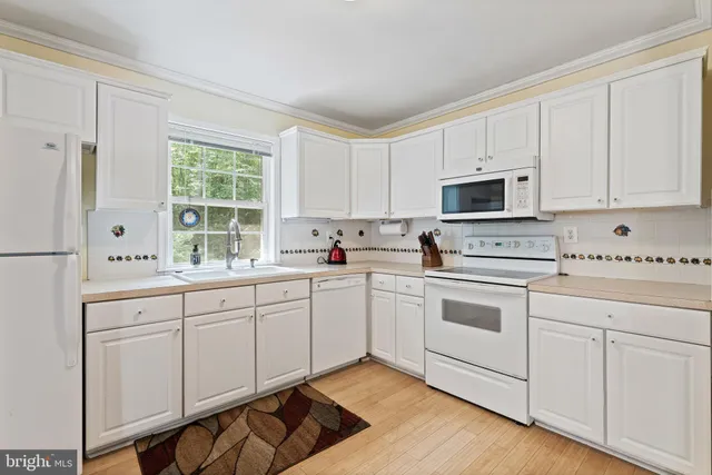 a kitchen with cabinets appliances a sink and a window