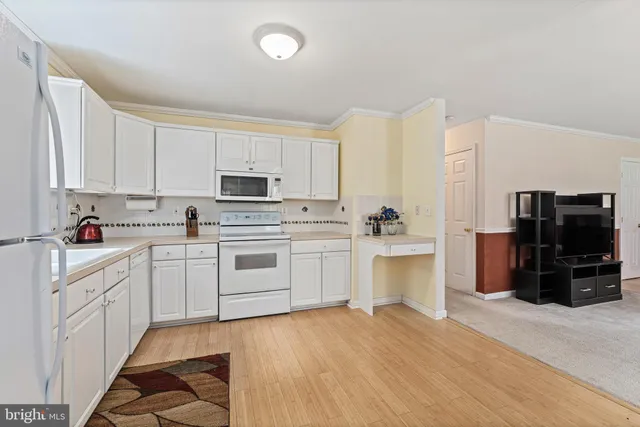 a kitchen with granite countertop white cabinets and white appliances