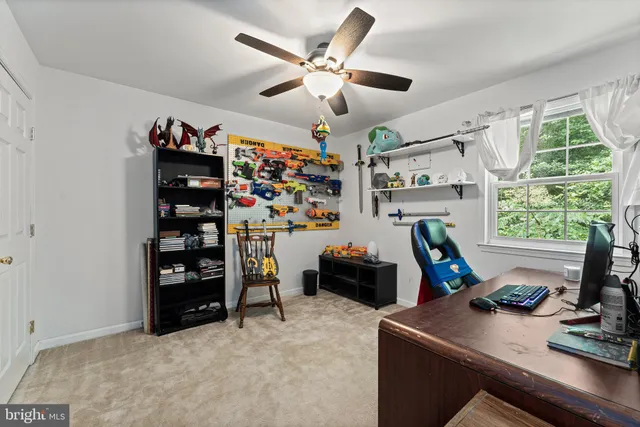 a view of workspace with furniture and ceiling fan