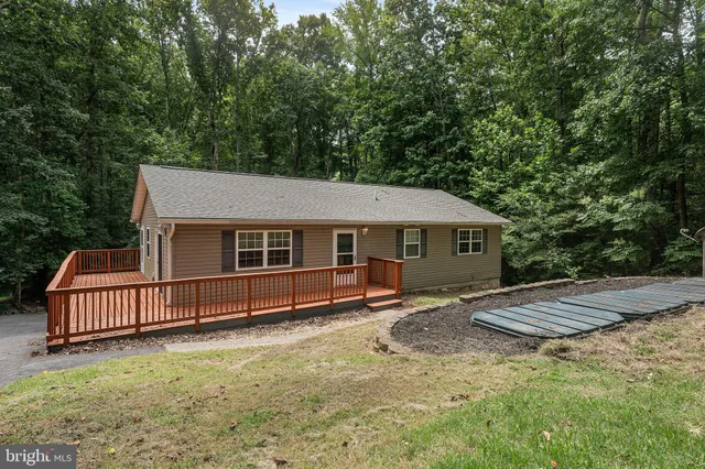 a view of a house with a yard and wooden fence