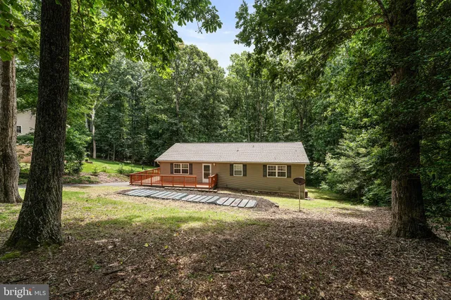a view of a house with backyard and trees