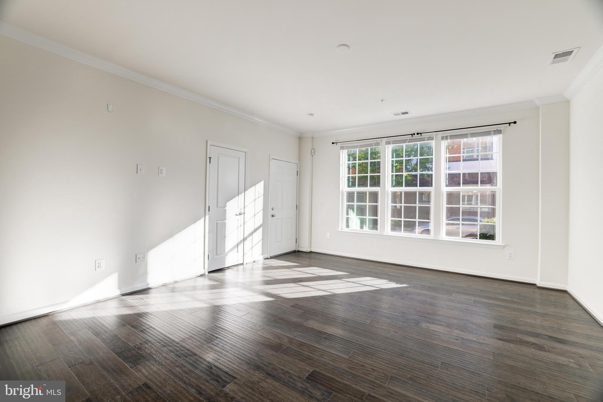 13660 Endeavour Drive, Unit 20C Herndon, VA 20171 - Photo 15 of 35 a view of an empty room with wooden floor and a window