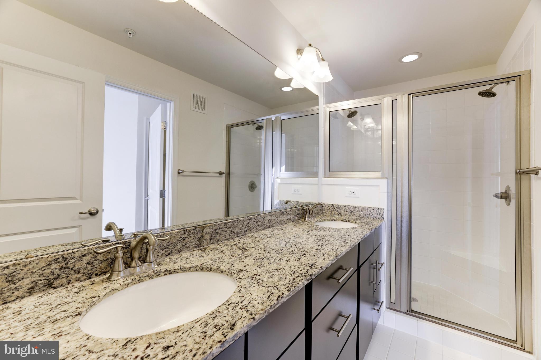 13660 Endeavour Drive, Unit 20C Herndon, VA 20171 - Photo 21 of 35 a bathroom with a granite countertop sink a mirror and a shower