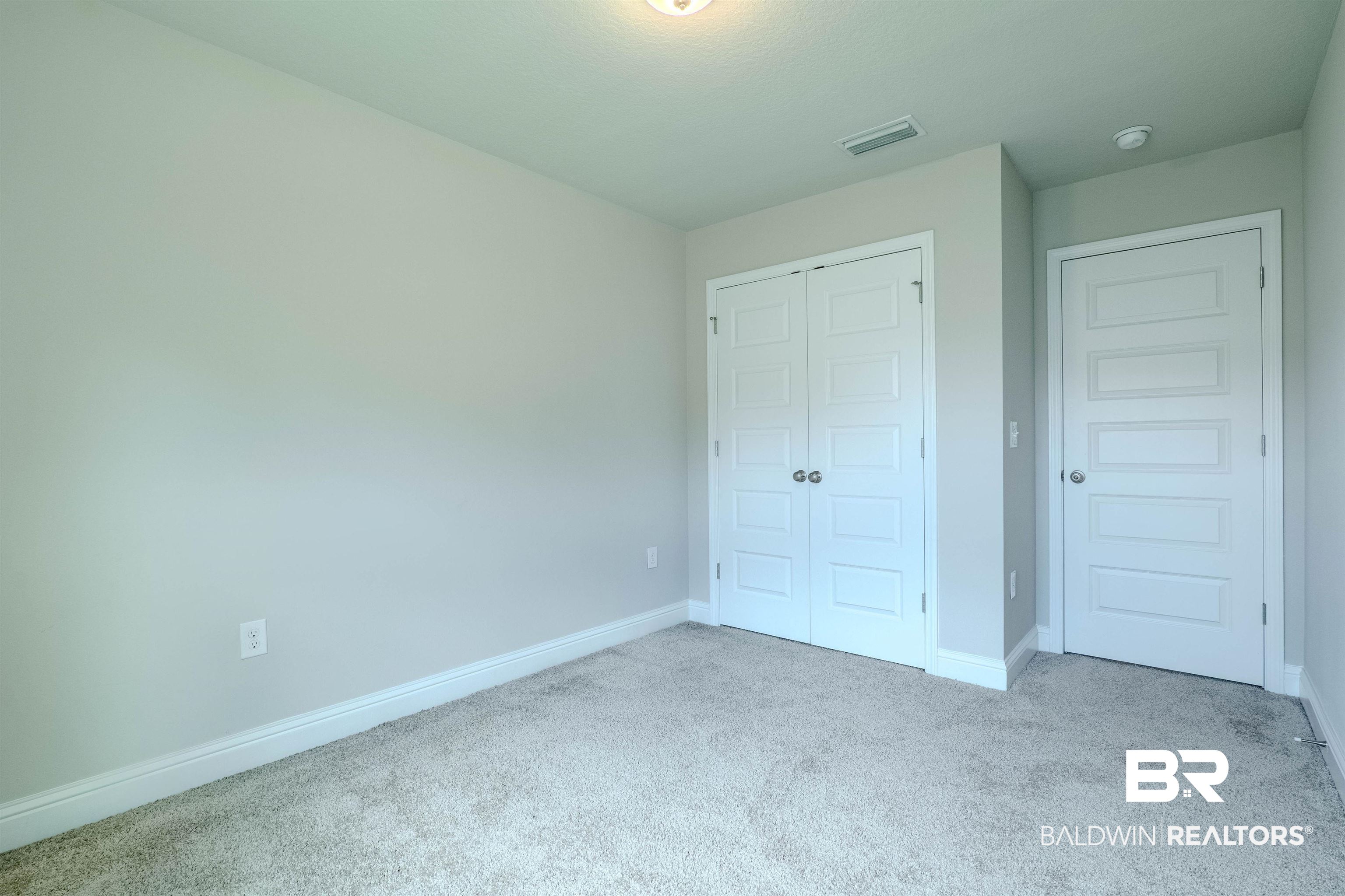 25806 Pollard Road, Unit 32 Daphne, AL 36526 - Photo 16 of 23 Unfurnished bedroom featuring a closet and light colored carpet