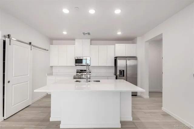 a kitchen with stainless steel appliances a refrigerator sink and microwave