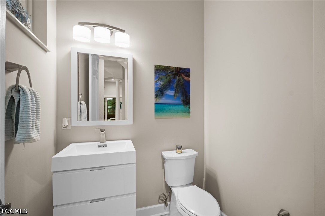 9042 Bronco Court Naples, FL 34113 - Photo 14 of 50 a bathroom with a toilet sink and mirror
