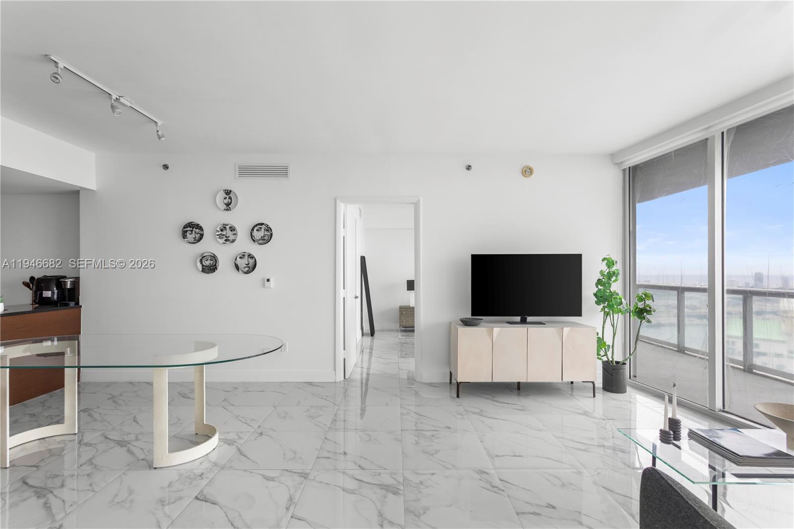 465 Brickell Avenue, Unit 5505 Miami, FL 33131 - Photo 11 of 25 a living room with furniture and a flat screen tv