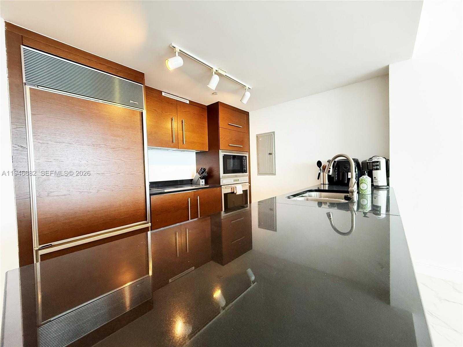 465 Brickell Avenue, Unit 5505 Miami, FL 33131 - Photo 6 of 8 a kitchen with stainless steel appliances granite countertop a refrigerator and a sink