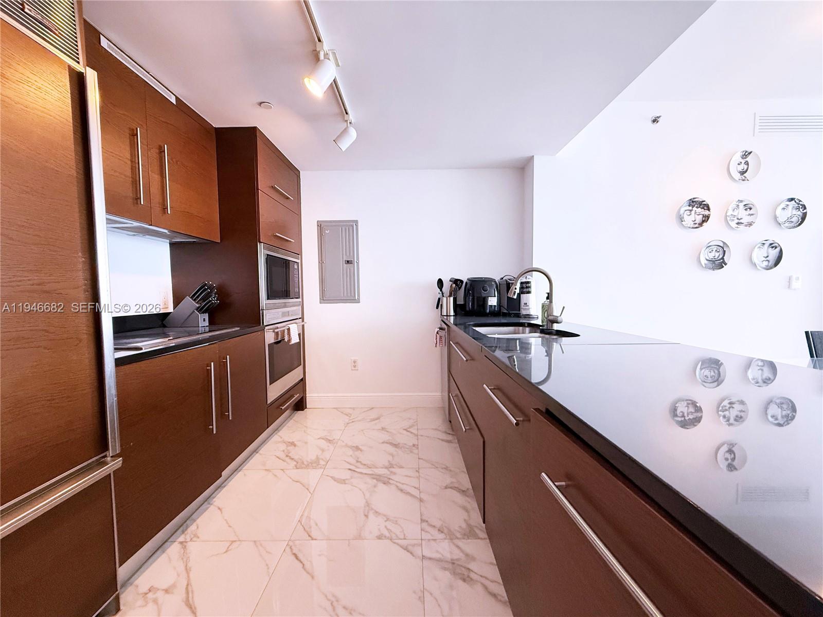 465 Brickell Avenue, Unit 5505 Miami, FL 33131 - Photo 7 of 8 a kitchen with stainless steel appliances granite countertop a sink stove and refrigerator