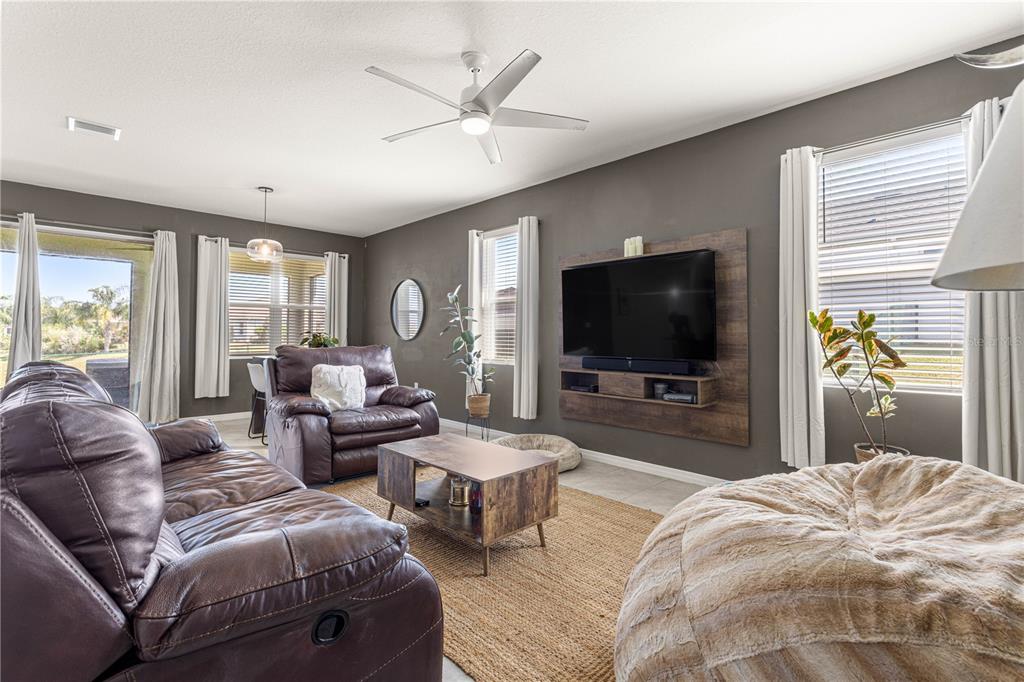 6233 Southwest 89th St Road Ocala, FL 34476 - Photo 12 of 39 a living room with couches a flat screen tv and a large window