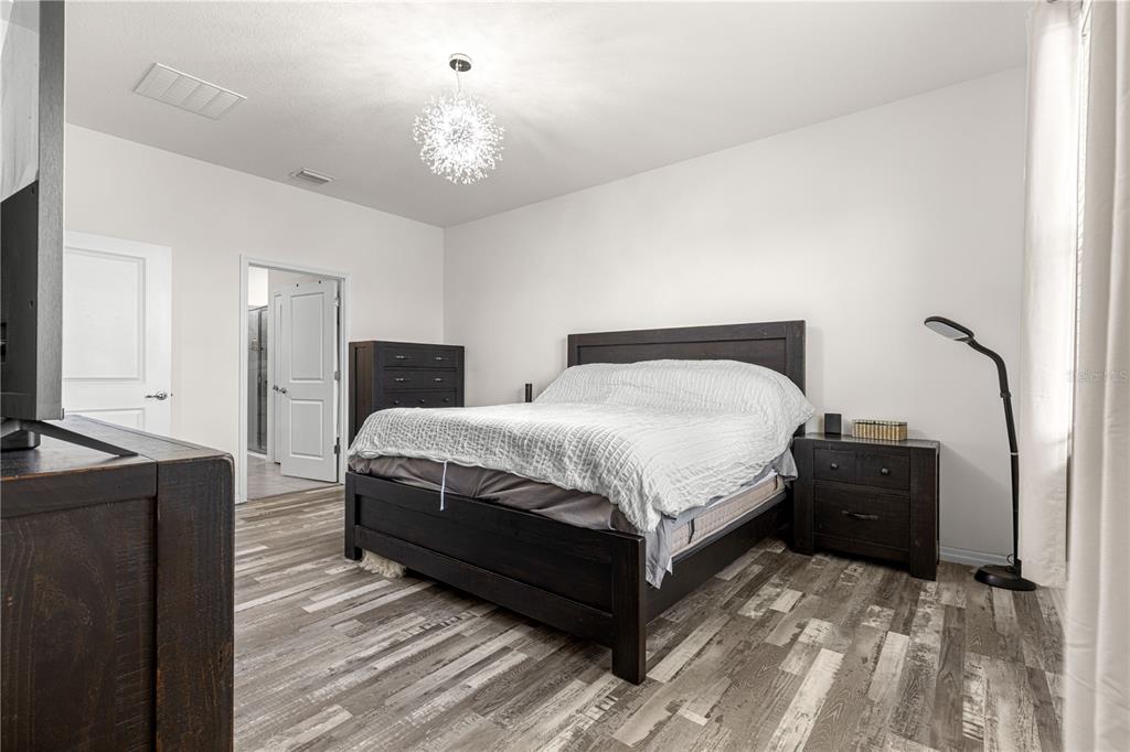 6233 Southwest 89th St Road Ocala, FL 34476 - Photo 15 of 39 a bedroom with a bed and a chandelier