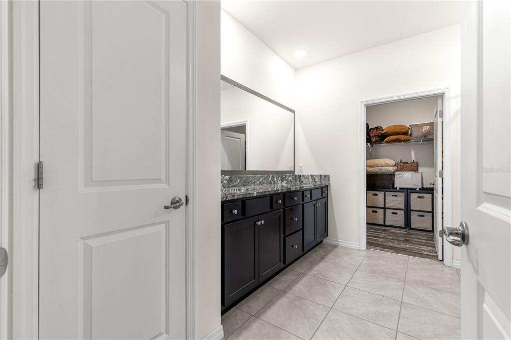 6233 Southwest 89th St Road Ocala, FL 34476 - Photo 21 of 39 a spacious bathroom with a granite countertop sink and a mirror